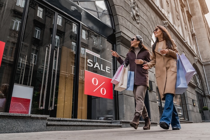 pvc banners printing, friends walking by a retail shop and looking at the signs and banners