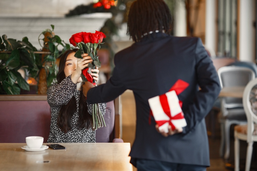 valentines day marketing guide, a man giving a bouquet of flowers to his Valentine