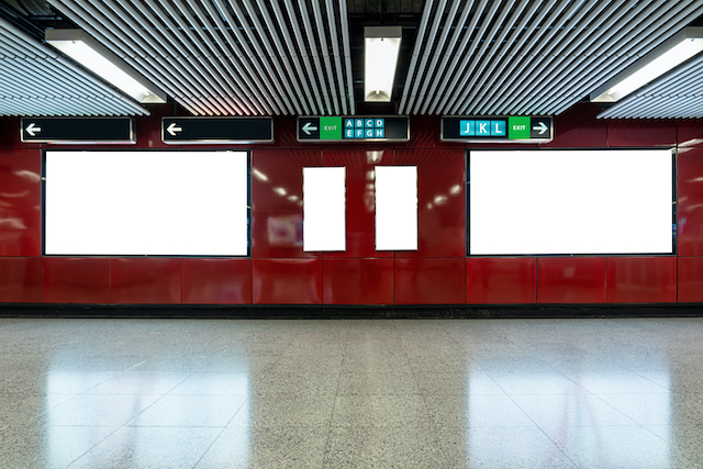 Indoor advertising vs outdoor advertising, billboards at a subway station.