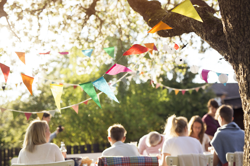 Event bunting, bunting hanging above table and guests at party