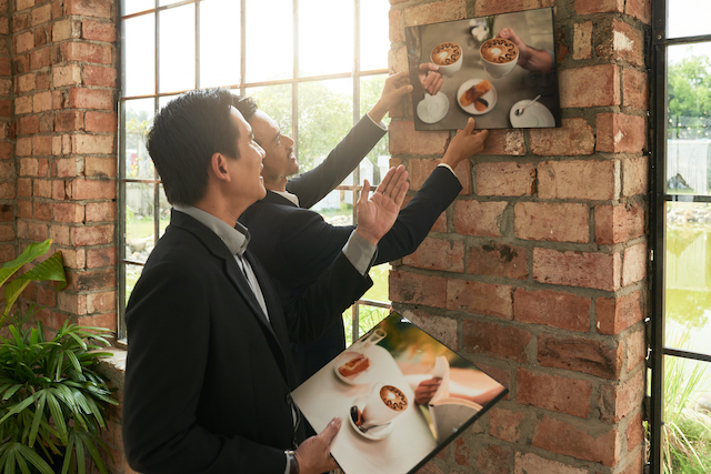 Restaurant Advertising Ideas, restaurant staff adding images on walls.