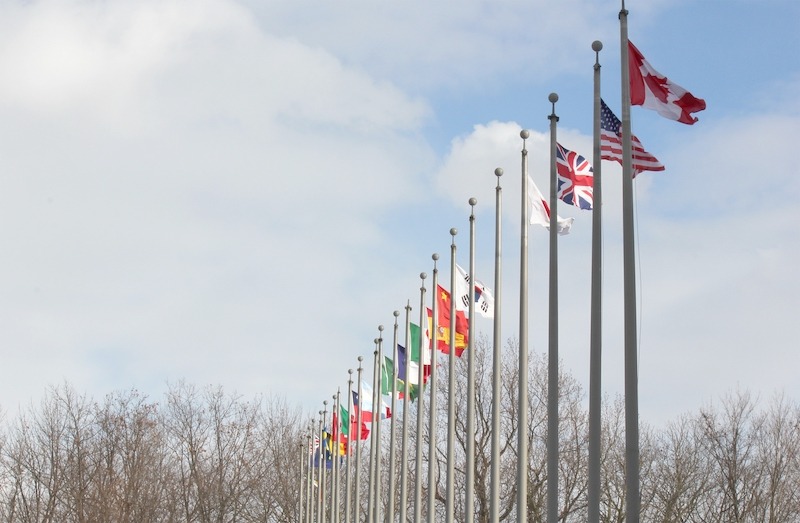 Aluminium flagpoles for hospitality businesses, tall white flagpoles with country flags clustered.