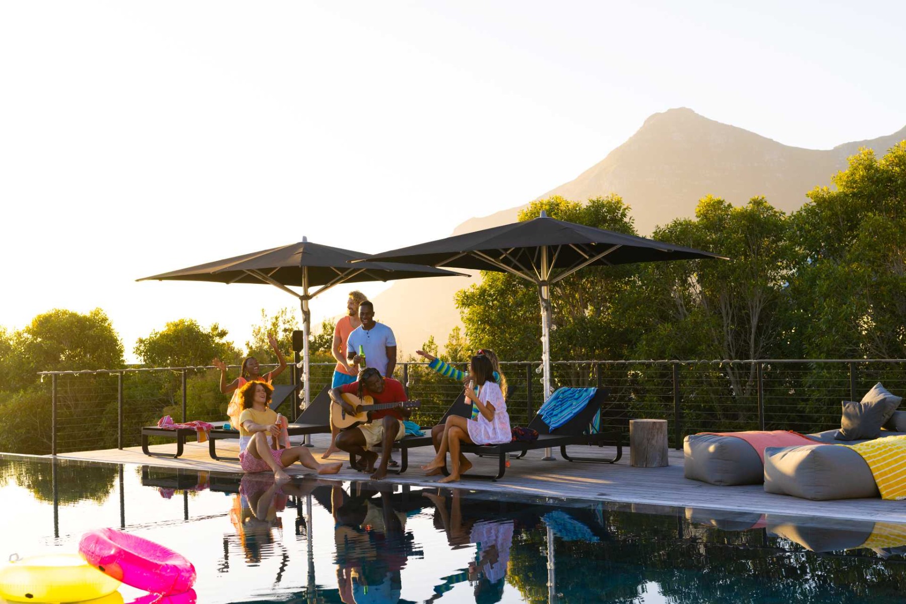 how to clean a parasol, A group sitting a long a poolside cafe.
