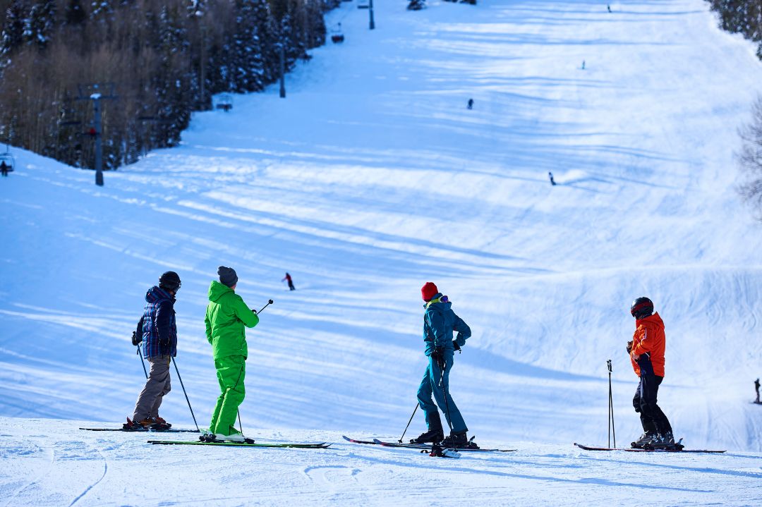 how to use feather flags at sports event, 4 skiers looking out at the ski slopes