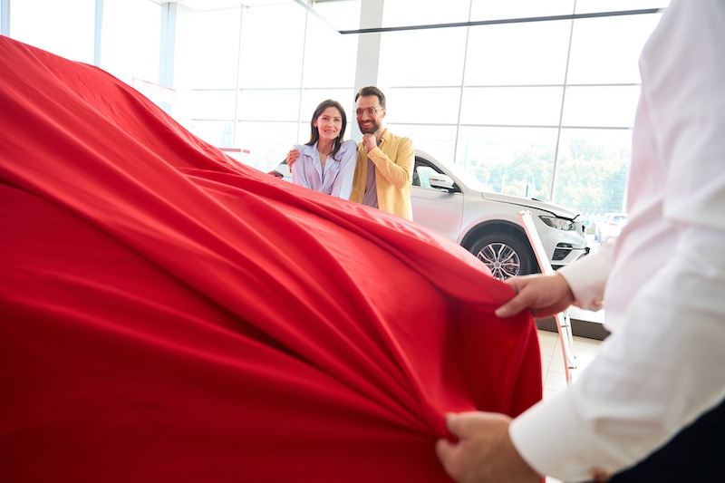 Improve Car Sales, couple buying a car at a dealership.