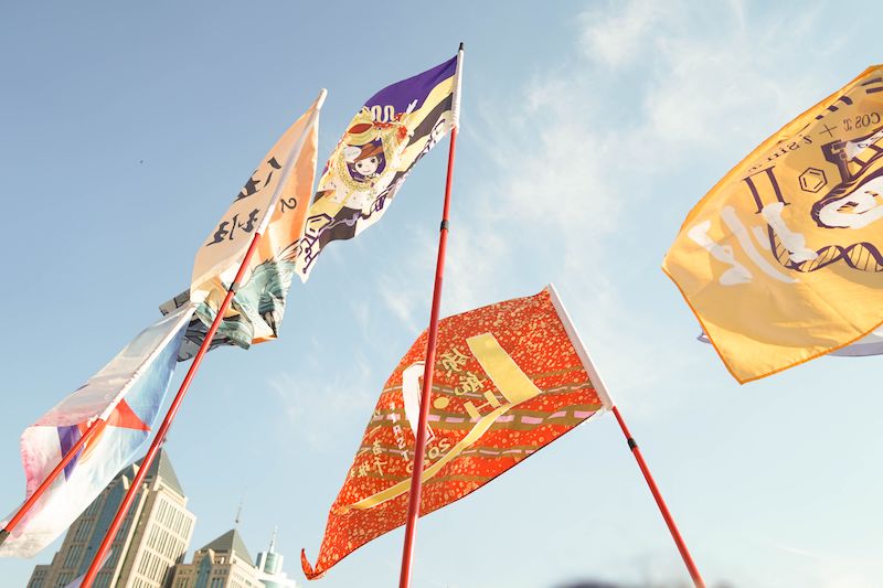 What are high-quality flags made of, multiple colourful flags on tall poles.