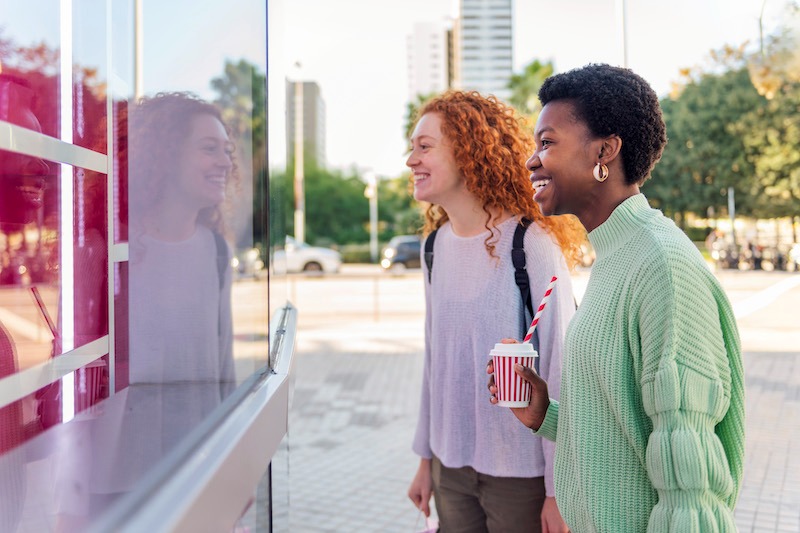 Franchise brand identity, women looking at shop window displays.