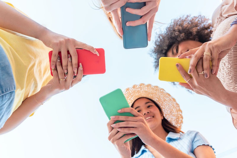 Digital vs physical marketing, 4 people scrolling on their phones.