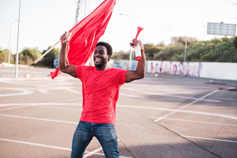 Flag Size Guide, man celebrating with a flag in hand.