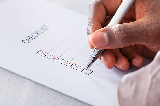 Trade show budget, a hand ticking boxes on a checklist.