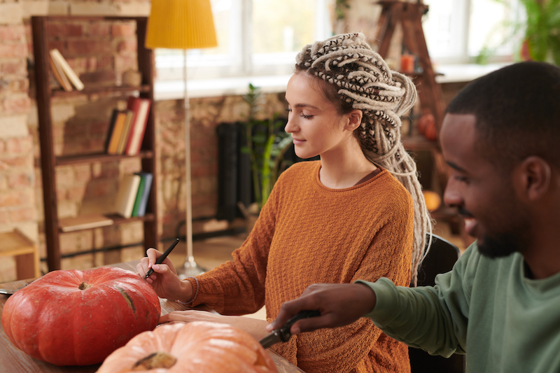 Halloween Branding, man and woman carving pumpkins.