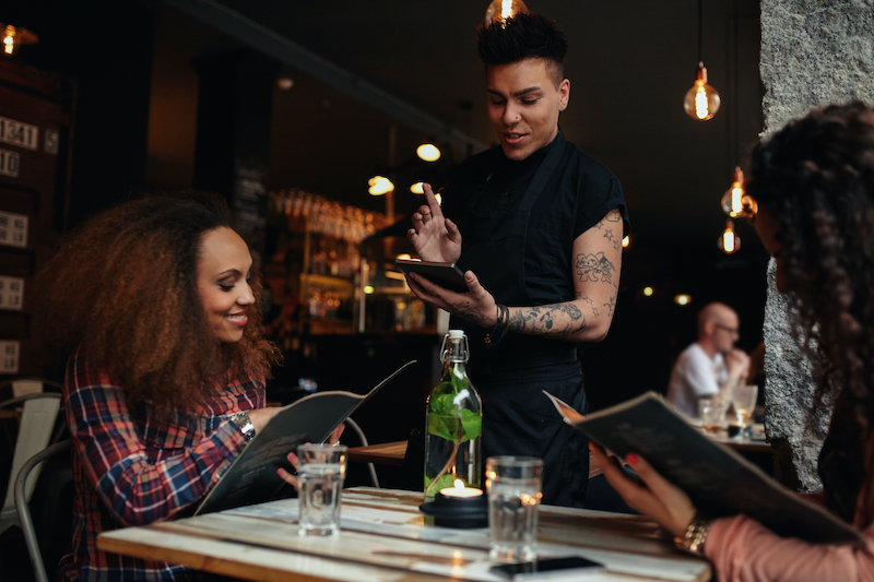 Restaurant Advertising Ideas, restaurant server taking orders from customers.