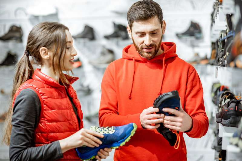 Olympic Experience, man and woman choosing sports shoes in a store.